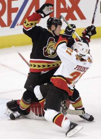 Chris Neil z Ottawy Senators se v zápase NHL srazil s Andrew Ferencem z Calgary Flames. | Foto: Reuters