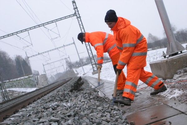 Dělníci zasypávají místo, kde stály schůdky, po kterých účastníci slavnostního otevření sestoupili na koleje. | Foto: Josef Mašek