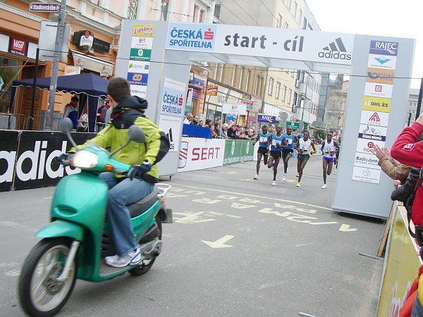 Tak kde jste, hoši? Muž na motocyklu přivádí do druhého kola čelo závodu, složené výhradně z keňských běžců. | Foto: Zuzana Hronová