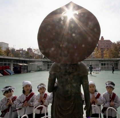 Děti obětují rýžový koláč Bohyni Kannon během výroční slavnosti ve školce Sensoji v japonském Tokiu. | Foto: Reuters