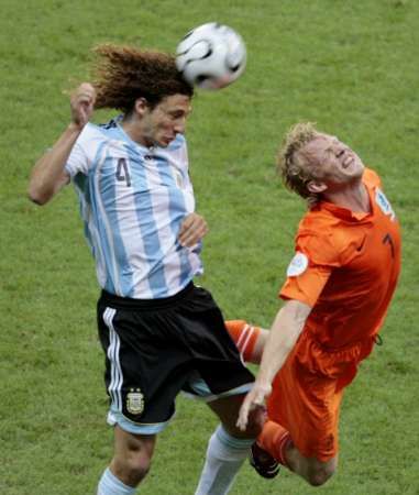 Argentinec Fabricio Coloccini v hlavičkovém souboji s Nizozemcem Dirkem Kuijtem. | Foto: Reuters