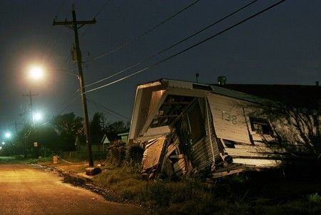 Pouliční světla svítí na dům zničený hurikánem Katrina v New Orleans... | Foto: Reuters