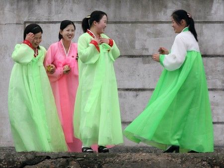 Severokorejské ženy v tradičních šatech ve městě Sinujiu na severokorejské straně řeky Ja-lu, která odděluje Severní Koreu od Číny | Foto: REUTERS / Reinhard Krause