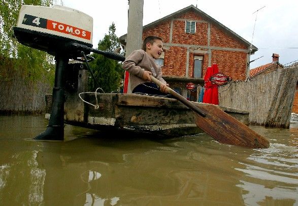 Ne všichni mají z povodně strach. Chlapec si hraje na loďce ve vesnici Ritopek nedaleko srbského Bělehradu. | Foto: Reuters