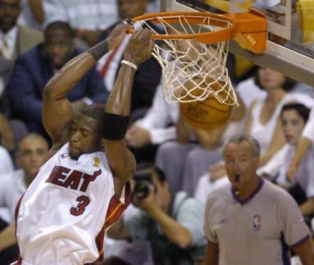 Hráč Miami Heat Dwyane Wade zakončuje efektní smečí při třetím finálovém utkání NBA proti Dallas Mavericks. | Foto: Reuters