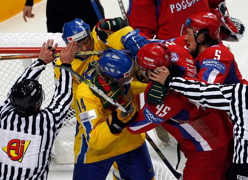 Čárový rozhodčí se snaží rozthnout bitku v zápase Švédska (ve žlutém) s Ruskem. | Foto: Reuters