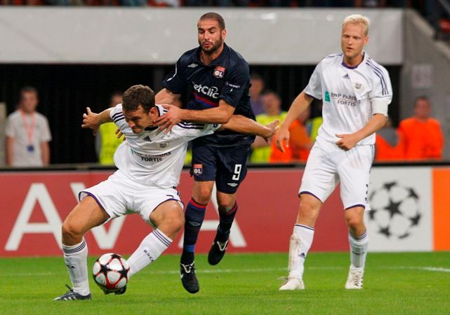 Lyonský Lisandro bojuje o míč s Rolandem Juhaszem z Lyonu v odvetě předkola Ligy mistrů. | Foto: Reuters