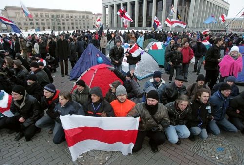 Demonstranti v úterý ráno na Říjnovém náměstí v Minsku. Příznivci opozice mají "své" běloruské vlajky. Oficiální běloruská vlajka je zelenočervená - stejná, jako ta z dob Sovětského svazu | Foto: Reuters