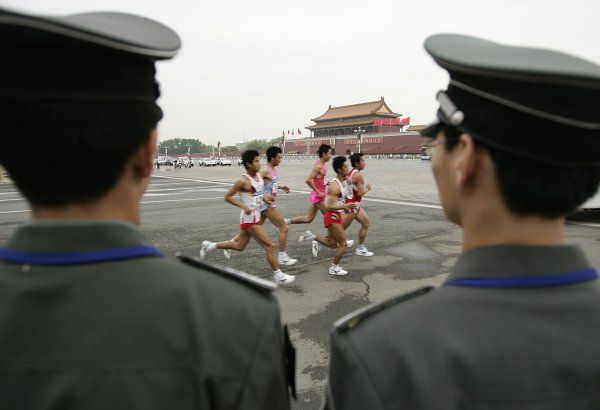 Maraton počínsku: náměstí Tiananmen (náměstí Nebeského klidu), závodníci a strážníci. | Foto: Reuters