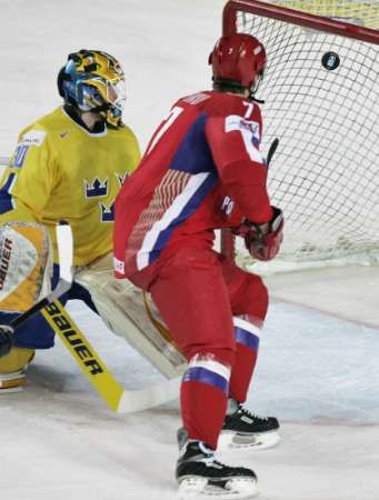 Ruský hokejista Alexej Michnov skóruje proti švédskému gólmanovi Johanu Holmqvistovi. | Foto: Reuters