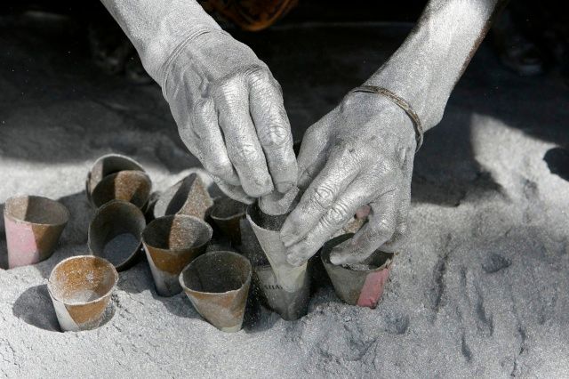 Dělník plní střelným prachem dělbuchy v továrně v indickém městě Siliguri. | Foto: Reuters