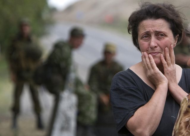 Žena sleduje valící se ruské tanky na hranice Gruzie a Jižní Osetie. | Foto: Reuters