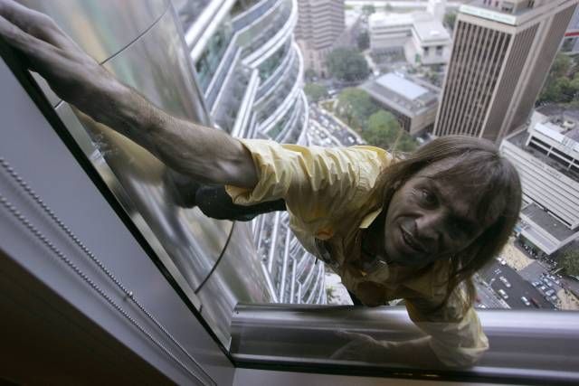 V půlce cesty na vrchol: Alain Robert vytahuje své pavoučí tělo do dvaatřicátého patra mrakodrapu Petronas Twin Towers. | Foto: Reuters