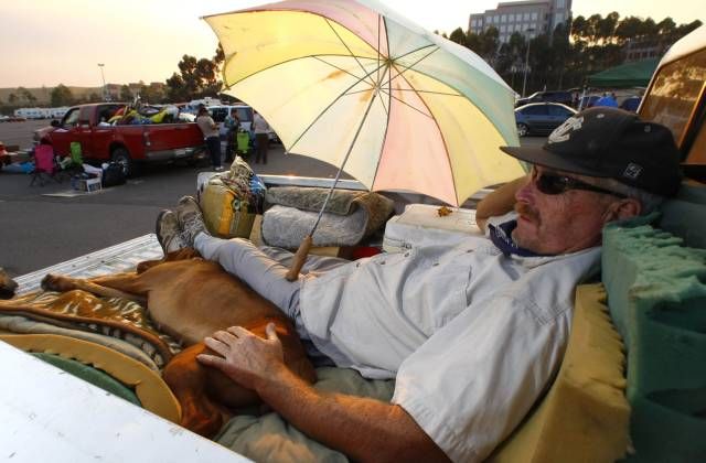 Jeden z evakuovaných - Michael z Escondída, bivakuje na korbě svého pickupu v San Diego. | Foto: Reuters