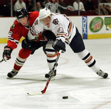 Aleš Hemský z Edmontonu (v bílém) se snaží uniknout chicagskému obránci Duncanu Keithovi. | Foto: Reuters