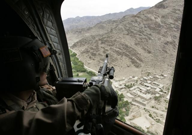 Voják NATO pátrá po tálibáncích z relativního bezpečí vojenské helikoptéry. | Foto: AP Photo