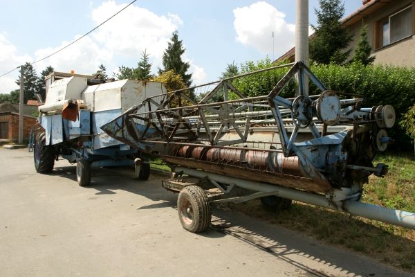 "Je to jako přesednout z Trabanta do Audiny," přibližuje kombajnista rozdíl mezi starým a novým kombajnem. Když po vyučení roku 1984 pracoval v nedalekém družstvu, mělo těchto kombajnů deset. Teď má nových jen čtyři a obilí je sklizeno dřív něž kdysi. Dnes se E512 v inzerátech na webu se prodává za cenu kolem 55 tisíc korun. | Foto: Karel Toman