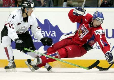 Guntis Galvins z Lotyška (v bílém) posíla k zemi českého útočníka Jana Hlaváče. | Foto: Reuters