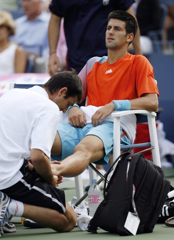 Novak Djokovič si nechal zatejpovat zraněný kotník a dokráčel k vítězství. | Foto: Reuters