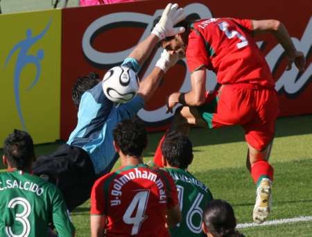 Mexický gólman Oswaldo Sanchez (v modrém) likviduje šanci Rahman Rézaie z Íránu (vpravo). | Foto: Reuters