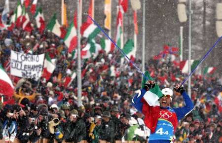 Cristian Zorzi dobíhá pro zlato ve štafetě 4x10 km, italští fanoušci jsou v euforii. | Foto: Reuters