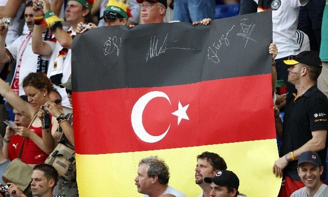 Fanoušci v hledišti basilejského stadionu drží před startem prvního semifinále Eura "německo-tureckou vlajku". | Foto: Reuters