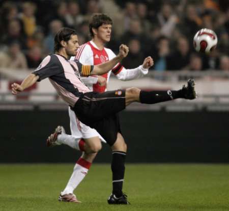 Daniel Jarque z Espanyolu Barcelona bojuje o míč s Janem Huntelaarem z Ajaxu Amsterodam v zápase Poháru UEFA. | Foto: Reuters