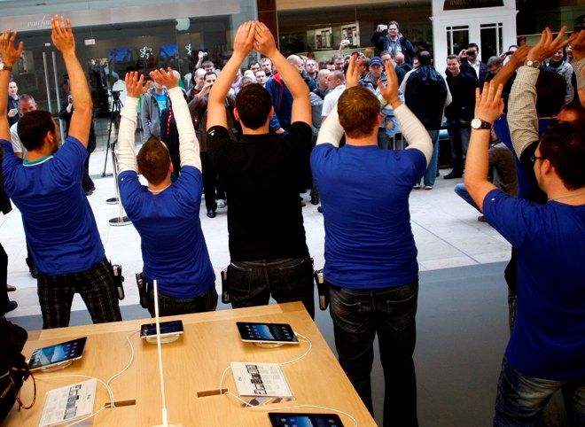 Ještě je chvilku napneme, rozhodli se sadisticky prodavači hamburského obchodu Apple a před otevřením na čekající mávali přes sklo. | Foto: Reuters