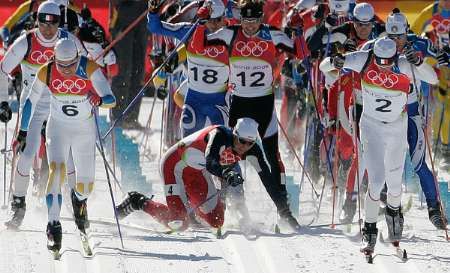 Frode Estil padá během masového startu závodu na 30 km. Za chvíli už na něm byla valná hromada závodníků. | Foto: Reuters