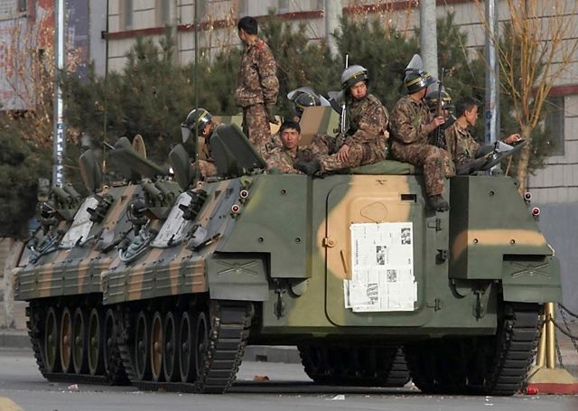 Čínští vojáci odpočívají na obrněném vozidle v ulicích tibetské Lhasy. | Foto: Reuters