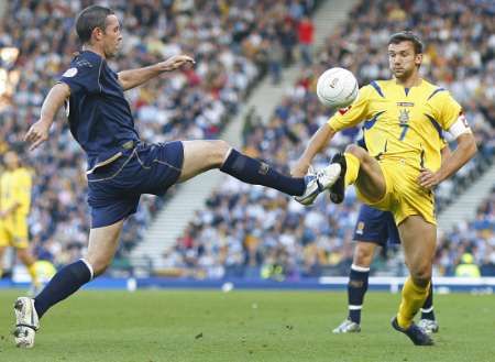 David Weir se snaží zastavit andreje Ševčenka v kvalifikačním duelu Ukrajiny se Skotskem. | Foto: Reuters