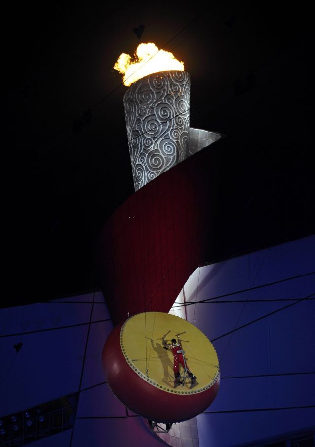 Bubeník pod olympijském ohněm během závěrečného ceremoniálu. | Foto: Reuters