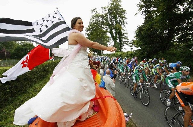 Tahle žena se na Tour de France vypravila ve variaci na svatební šaty dokonce na lodi... | Foto: Reuters