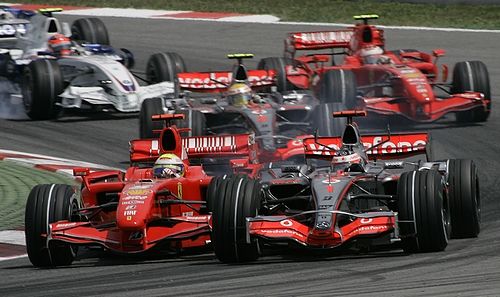 Fernando Alonso s McLarenem (vpravo) se pokusil hend po startu Velké ceny Španělska z aútočit na vedoucího Felipe MAssu s Ferrari. | Foto: Reuters