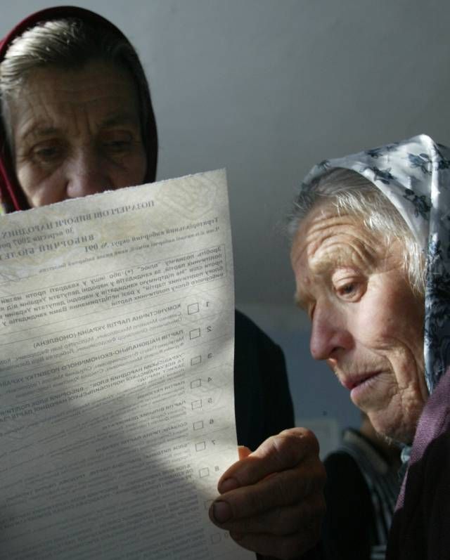 Stařenky studují volební lístky ve vesnici Lyčanka, zhruba třicet kilometrů od hlavního města. | Foto: Reuters