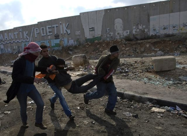 Palestinci v Gaze odnášejí zraněného chlapce. Boji trpí civilní obyvatelstvo. Podle palestinské strany je mrtvých několik set | Foto: Reuters