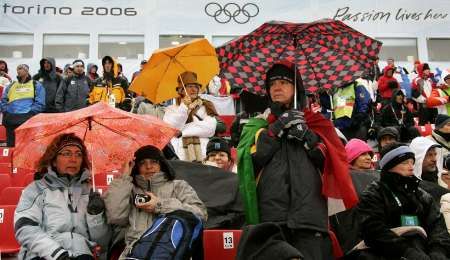 Divácí s deštníky sledují olympijský běh žen na 10 km. Při závodě hustě pršelo. | Foto: Reuters