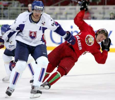 Slovenský hokejista Štrbák odstrkuje Bělorusa Grabovskyho. Běloruská pomoc se nakonec hodila. | Foto: Reuters