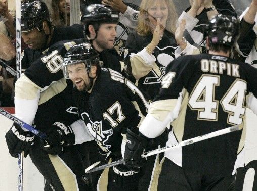 Český hokejista Pittsburghu Penguins Petr Sýkora (uprostřed) slaví svůj druhý gól do sítě Anaheimu s Ryanem Whitneyem a Brooksem Orpikem. | Foto: Reuters