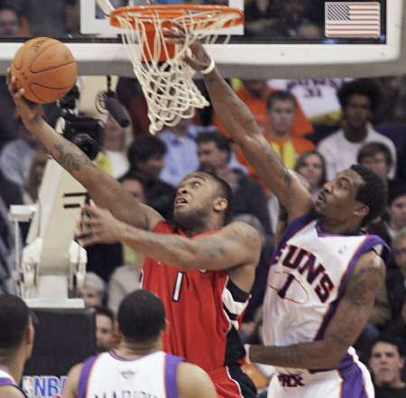 P.J. Tucker z Toronta (vlevo) se snaží dát koš tísněný hráčem Phoenixu Amare Stoudemirem. | Foto: Reuters