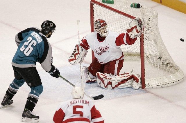 Detrotiský gólman Dominik Hašek chytá šanci Stevu Bernierovi ze San Jose v šestém zápase čtvrtfinále play off NHL. | Foto: Reuters