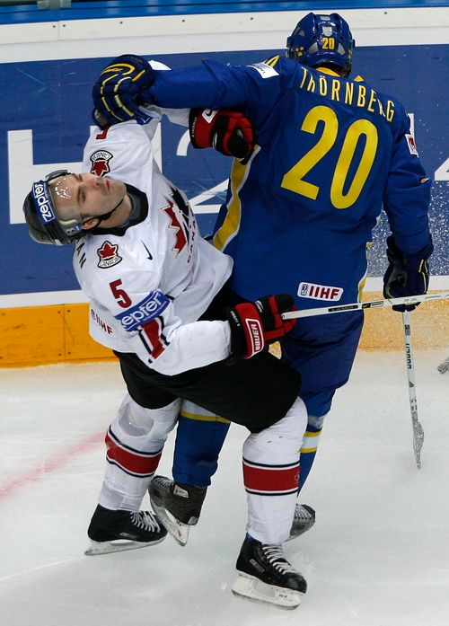 Kanaďan Barret Jackman (v bílém) padá na zem atakovaný Martinem Thornbergem ze Švédska. | Foto: Reuters