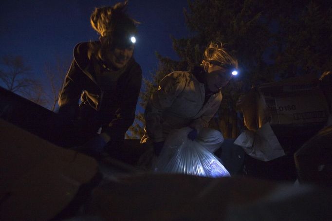 Anna-Rae Douglass (R), 23, and Robin Pickell, 24, practising 'freegans', search through a dumpster behind an organic grocery store in Coquitlam, British Columbia April 5, 2012. A 'freegan' is someone who gathers edible food from the garbage bins of grocery stores or food stands that would otherwise have been thrown away. Freegans aim to spend little or no money purchasing food and other goods, not through financial need but to try to address issues of over-consumption and excess. Picture taken April 5, 2012. REUTERS/Ben Nelms (CANADA - Tags: SOCIETY) ATTENTION EDITORS PICTURE 18 OF 21 FOR PACKAGE 'DUMPSTER DIVING FOR FOOD' Published: Kvě. 15, 2012, poledne