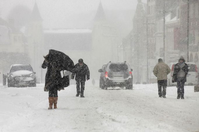 Pedestrians walk on a snow-covered street in Cambrai, northern France, March 12, 2013 as winter weather with snow and freezing temperatures returns to northern France. REUTERS/Pascal Rossignol (FRANCE - Tags: ENVIRONMENT) Published: Bře. 12, 2013, 9:43 dop.