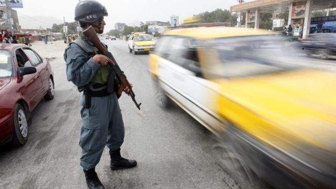 Voják hlídkuje uprostřed silnice v Kábulu.