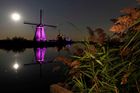 Barevně nasvícené větrné mlýny u Kinderdijku, které jsou zapsány v seznamu světového kulturního dědictví UNESCO.