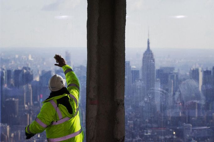 The Empire State Building stands behind a worker as they clean the windows of the 100th floor observation deck in One World Trade Center before a press conference in New York, April 2, 2013. Port Authority officials unveiled Tuesday the stunning view from the top of One World Trade Center, a 360-degree eagle�s eye panorama that will instantly become one of the city�s premiere tourist attractions when it is completed in 2015. REUTERS/Lucas Jackson (UNITED STATES - Tags: CITYSPACE BUSINESS CONSTRUCTION) Published: Dub. 2, 2013, 4:37 odp.