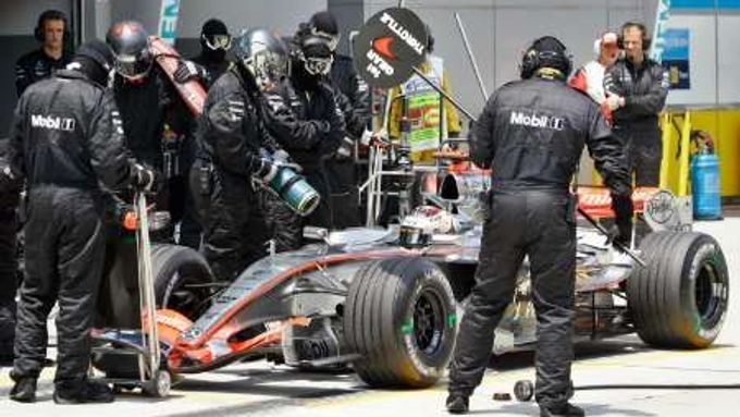 Kimi Räikkönen tankuje svůj McLaren při kvalifikaci v Sepangu.