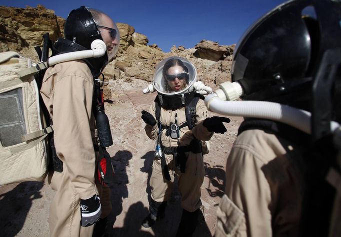 Melissa Battler (C), a geologist and commander of Crew 125 EuroMoonMars B mission, talks to members of the crew about collecting geologic samples for study at the Mars Desert Research Station (MDRS) in the Utah desert March 2, 2013. The MDRS aims to investigate the feasibility of a human exploration of Mars and uses the Utah desert's Mars-like terrain to simulate working conditions on the red planet. Scientists, students and enthusiasts work together developing field tactics and studying the terrain. All outdoor exploration is done wearing simulated spacesuits and carrying air supply packs and crews live together in a small communication base with limited amounts of electricity, food, oxygen and water. Everything needed to survive must be produced, fixed and replaced on site. Picture taken March 2, 2013. REUTERS/Jim Urquhart (UNITED STATES - Tags: SCIENCE TECHNOLOGY SOCIETY ENVIRONMENT) ATTENTION EDITORS: PICTURE 15 OF 31 FOR PACKAGE 'MARS IN THE DESERT' SEARCH 'JIM MARS' FOR ALL IMAGES Published: Bře. 11, 2013, 2:04 odp.