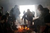 Uprchlíci si připravují jídlo v nevyužívaném skladišti.